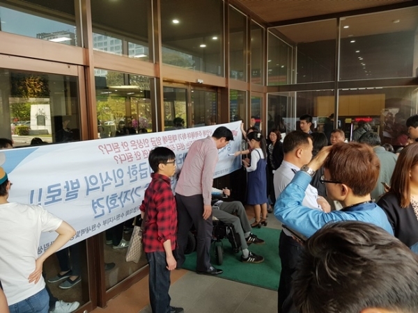 3일 오후 수원시청 본관 정문에서 수원시 장애인 단체들이 청사 진입을 시도하고 있다. 채태병기자