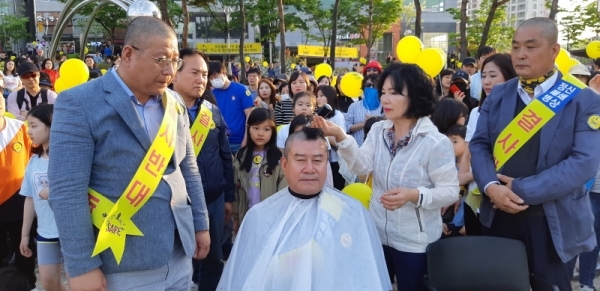 삭발을 마친 전도현 세교주민연합회장(좌)과 김우종 위원장(우)이 지켜보는 가운데 이상복 시의원의 삭발을 하고 있다.