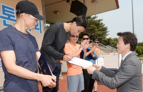`2019 과천마라톤대회`가 열린 12일 오전 과천관문체육공원에서 김종천 과천시장과 남성 하프부분 수상자들이 기념촬영하고 있다. 윤원규 기자