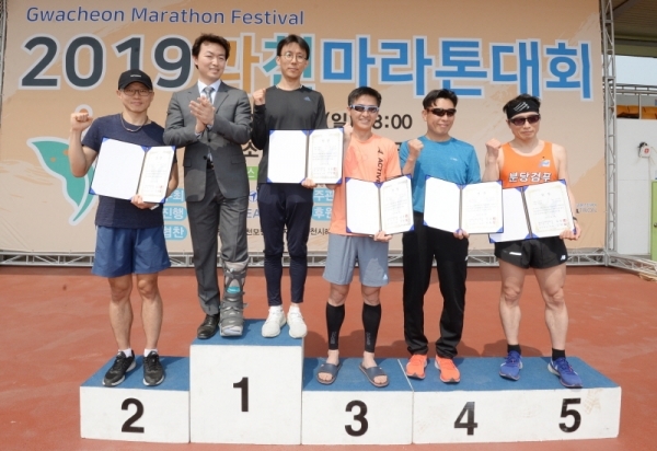 `2019 과천마라톤대회`가 열린 12일 오전 과천관문체육공원에서 김종천 과천시장과 남성 하프부분 수상자들이 기념촬영하고 있다. 윤원규 기자