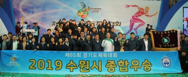 제65회 경기도체육대회에서 1부 종합우승 2연패를 달성한 수원시선수단이 우승기와 우승배를 들고 기념촬영을 하고 있다.경기도체육회 제공-