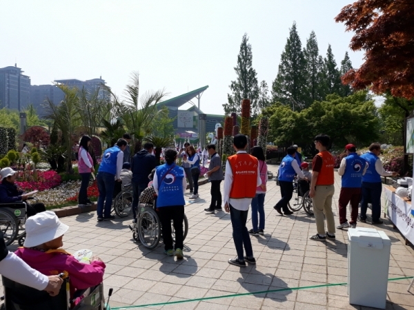 사진=법무부 고양준법지원센터 가종료 보호관찰자들이 노인들의 고양국제꽃박람회 관람을 돕는 휠체어 봉사활동을 하고 있다. 제공=고양준법지원센터