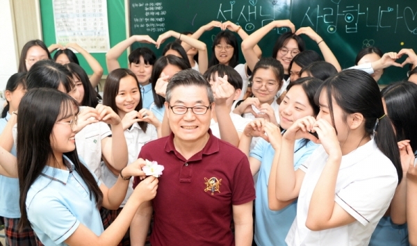스승의날을 하루 앞둔 14일 오전 수원시 팔달구 영복여자중학교 3학년 4반에서 정년을 3달 앞둔  정연성 음악선생님을 학생들이 웃으며 무궁화를 달아드리고 있다. 윤원규 기자