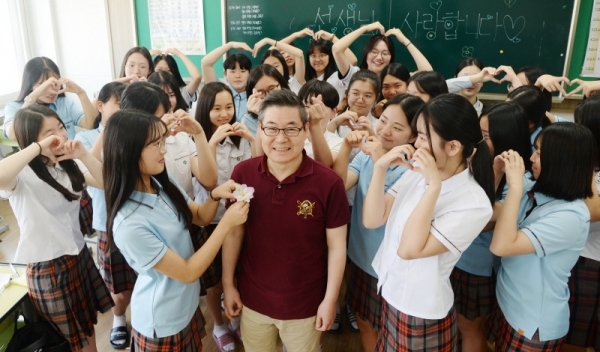 스승의날을 하루 앞둔 14일 오전 수원시 팔달구 영복여자중학교 3학년 4반에서 정년을 3달 앞둔  정연성 음악선생님을 학생들이 웃으며 무궁화를 달아드리고 있다. 윤원규 기자