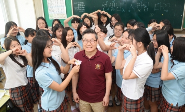 스승의날을 하루 앞둔 14일 오전 수원시 팔달구 영복여자중학교 3학년 4반에서 정년을 3달 앞둔  정연성 음악선생님을 학생들이 웃으며 무궁화를 달아드리고 있다. 윤원규 기자