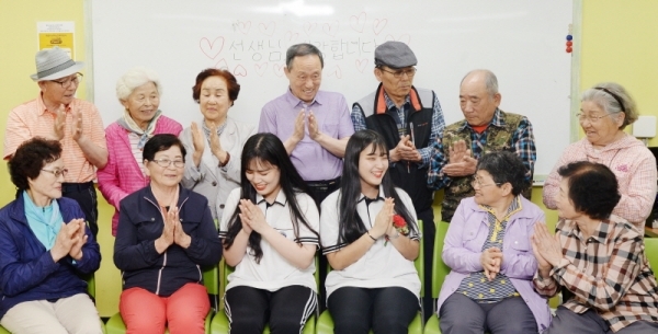 주 1회 어르신들 위한 스마트폰 교육을 진행하는 화성 향남고 학생들을 위해, 스승의날을 하루 앞둔 14일 화성시 향남읍 화성시남부노인복지관에서 어르신들이 어린 선생님들을 위해 카네이션을 달아주고 함께 즐거워하고 있다. 윤원규 기자