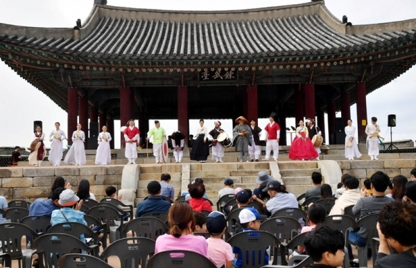 ‘제7회 수원화성 유랑콘서트 옹고집 외전’이 18일 수원화성 동장대에서 열려 시민들이 유랑극단의 신명나는 공연을 관람하고 있다.  (사)화성재인청보존회가 주최·주관하고 수원시, 수원문화재단, 경기일보가 후원한 이번 유랑콘서트는 ‘옹고집 외전’을 주제로 풍류도, 쟁강춤, 장고춤, 진도복춤 등 전통적인 요소와 비보잉 등 현대예술이 어울어진 ‘융복합 종합연희극’으로 다채로운 공연이 펼쳐졌다.전형민기자