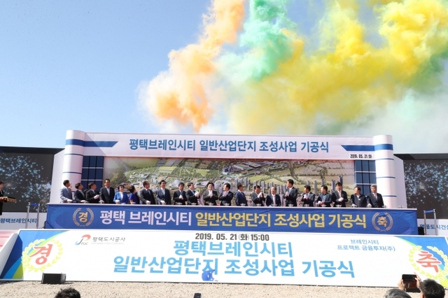 지난 21일 평택시 도일동 일원에서 열린 브레인시티 일반산업단지 기공식에서 참석한 내빈들이 축포 버튼을 누르자 오색 축포가 하늘 위로 터지고 있다.