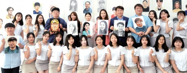 ▲ 안양예술고등학교 미술과 학생들이 5월 스승의 달을 맞아 직접 그린 선생님의 얼굴을 전시한 가운데 교사들 얼굴 특징을 다양하게 표현해 낸 초상화 앞에서 학생교사들이 손가락으로 사랑의 하트를 만들며 환하게 웃고 있다.  윤원규기자