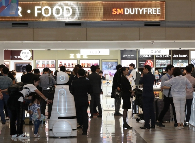 지난달 31일 인천공항 제2여객터미널에 문을 연 입국장 면세점에서 여행객이 물품을 살펴보고 있다. 연합뉴스