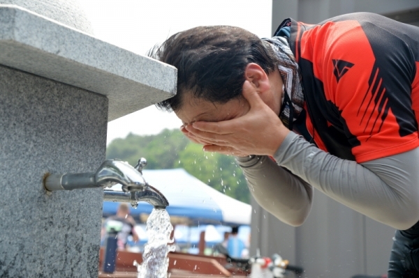 '2019 tour de DMZ' 가 경기도와 강원도 공동 주최로  열린 1일 철원군 철원공설운동장에서 참가자가 수돗가에서 세수하며 더위를 식히고 있다.  연천공설운동장부터 DMZ 평화문화광장, 철원공설운동장까지 총 54km의 코스를 한반도의 평화와 통일을 염원하며 주행했다. 윤원규기자
