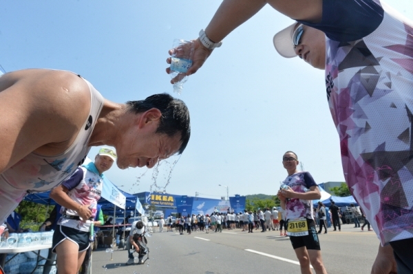 '2019 KTX 광명역 평화마라톤대회'가 열린 2일 광명역 도로에서 참가자가 더위를 식히고 있다. 남북평화고속철도 광명에서 개성까지 염원을 담아 열린 이번 대회는 광명시체육회와 KTX 광명역 남북평화철도 출발역 육성 범시민대책위가 주최하고 경기일보 등이 후원했다. 김시범기자