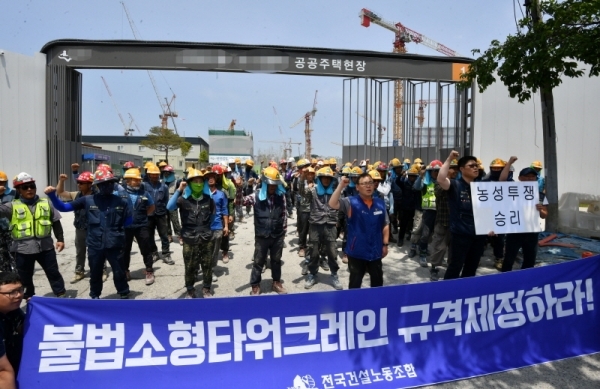 한국노총과 민주노총 소속 전국 타워크레인 노동자들이 4일 오전 3t 미만의 불법 소형타워크레인 규격제한을 요구하며 일제히 파업에 돌입했다. 파업에 돌입한 조합원들이 수원시내 한 공사현장 앞에서 농성을 벌이고 있다. 김시범기자