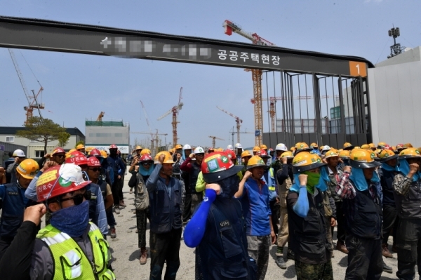 한국노총과 민주노총 소속 전국 타워크레인 노동자들이 4일 오전 3t 미만의 불법 소형타워크레인 규격제한을 요구하며 일제히 파업에 돌입했다. 파업에 돌입한 조합원들이 수원시내 한 공사현장 앞에서 농성을 벌이고 있다. 김시범기자