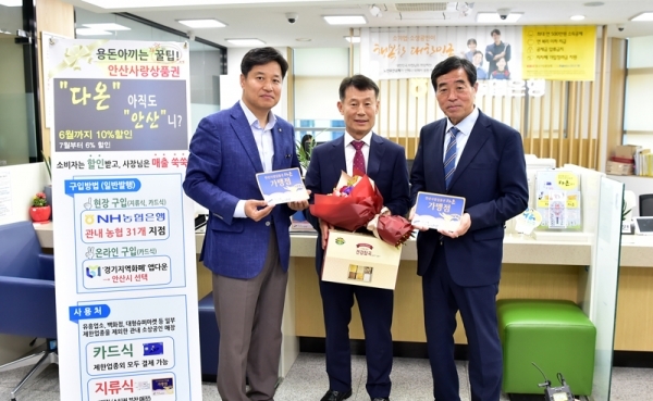 윤화섭 안산시장, 황준구 농협 안산시지부장(왼쪽)이 다온 판매액 50억 원 돌파를 기념하며 다온 구매 시민인 김용규씨와 기념촬영을 하고 있다.