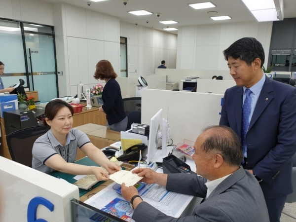 동두천농업협동조합 본점 금융사업장 리모델링 재개장 후 정진호 조합장(사진 중앙)과 남상식 NH농협 동두천시지지부장(사진 오른쪽)이 금융거래를 하고 있다.