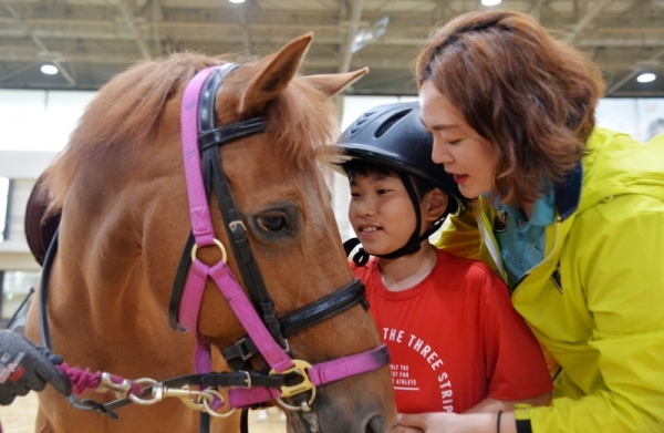 8일 오후 과천 한국마사회에서 열린 2019 경마공원 콘서트와 연계로 '난치성질환 소아환자 초청 기부금 전달식'에 참가한 어린이가 재활힐링승마센터에서 승마체험을 하며 즐거워하고 있다. 윤원규기자