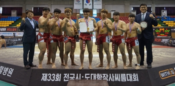 25일 열린 제33회 전국시도대항장사씨름대회 대학부 단체전에서 우승한 용인대의 이태현 감독(오른쪽)과 선수들이 기념 촬영을 하고 있다.대한씨름협회 제공