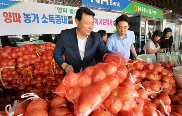 양파값 폭락으로 시름이 깊은 농가를 돕기 위해 25일 오전 경기도청에서 열린 ‘양파 팔아주기 운동’에서 도청 직원과 시민들이 NH농협은행 경기본부가 사은품으로 나눠주는 양파를 받아가고 있다.  윤원규기자