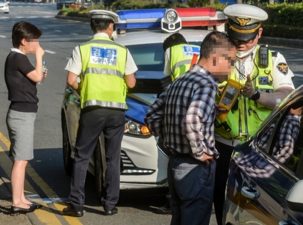 음주운전 단속 기준을 강화한 도로교통법 개정안이 시행된 첫날인 25일 오전 인천 부평구 삼산동 주공아파트 앞 도로에서 음주감지기에 적발된 운전자들이 음주측정을 받고 있다.조주현기자