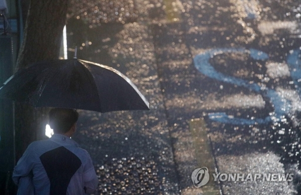 본격적인 장맛비가 내린 26일 오후 부산 동구 조방앞 거리에서 시민들이 발걸음을 재촉하고 있다. /연합
