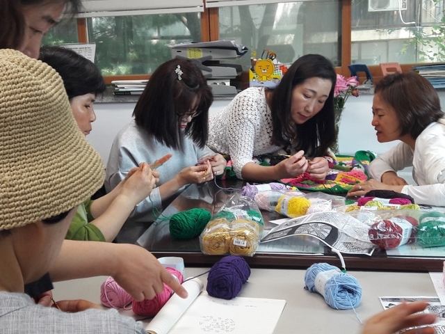 ▲ 광명시 철산2동 주민들이 가로수에 입힐 뜨개 옷을 정성스럽게 뜨고 있다. 광명시 제공