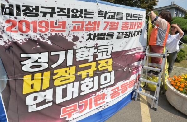 급식 조리 실무사와 돌봄교실 교사 등이 포함된 학교 비정규직 노조가 예고한 총파업을 하루 앞둔 2일 오후 경기도교육청 일원에 설치된 파업천막에서 노조원이 깃발을 고쳐달고 있다. 교육공무직이 가장 많은 경기지역의 경우 상당수 학교에서 급식 차질이 불가피할 것으로 예상된다. 윤원규기자