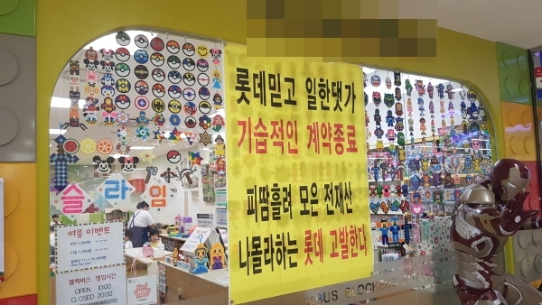 롯데마트 수지점의 한 점주가 가게에 플래카드를 내걸고 롯데마트의 횡포를 주장하고 있다.