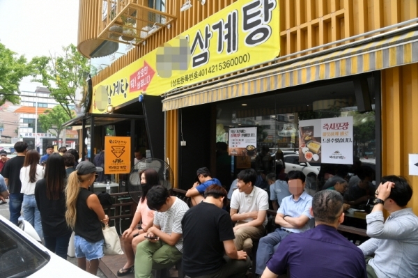 절기상 중복이자 대서를 하루 앞둔 22일 수도권지역에 폭염주의보가 내려진 가운데 수원시내 한 삼계탕집에 몰린 시민들이 삼계탕을 먹기위해 차례를 기다리고 있다. 김시범기자