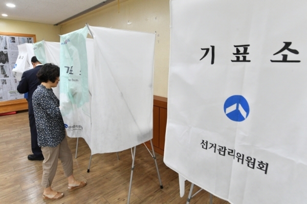 동장 투표를 하러 기표소에 들어가는 주민.