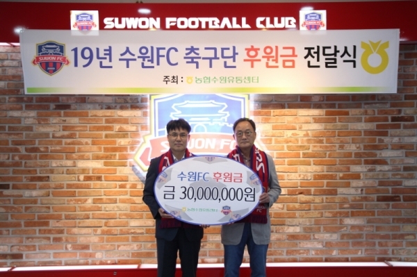 정승일 농협수원유통센터 지사장(왼쪽)이 김호곤 수원FC 단장에서 후원금을 전달한 뒤 기념촬영을 하고 있다. 농협수원유통센터 제공