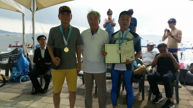 문성혁 해양수산부장으로부터 1등 메달과 상장을 수여받고 기념촬영을 하고 있다(사진 왼쪽).