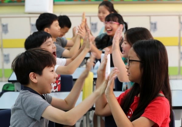 19일 오전 수원시 영통구 태장초등학교에서 여름방학을 마치고 만난 학생들이 서로 인사하고 있다.윤원규 기자