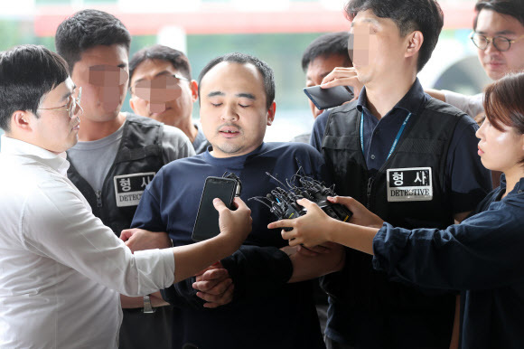 모텔 손님을 살해한 뒤 시신을 훼손해 한강에 유기한 혐의로 구속된 장대호(38)가 21일 오후 경기 고양경찰서에서 조사를 받기 위해 이동하고 있다. 경기북부지방경찰청은 20일 신상정보공개 심의위원회를 열어 장대호의 실명과 얼굴, 나이 등 신상을 공개하기로 했다. 연합뉴스