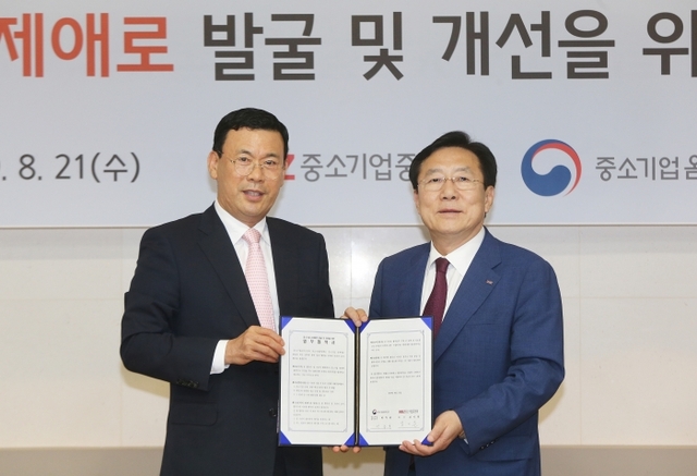 김기문 중소기업중앙회장(오른쪽)과 박주봉 중소기업옴부즈만이 21일 서울 여의도 중소기업중앙회에서 중소기업 규제애로 개선을 위한 업무협약을 체결한 뒤 기념촬영을 하고 있다.중기중앙회 제공