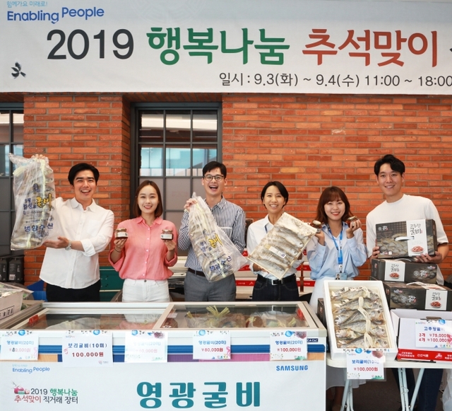 ▲ 3일 삼성디지털시티에서 열린 추석맞이 직거래 장터에서 삼성전자 임ㆍ직원들이 자매마을에서 생산된 상품들을 들어보이고 있다.삼성전자 제공