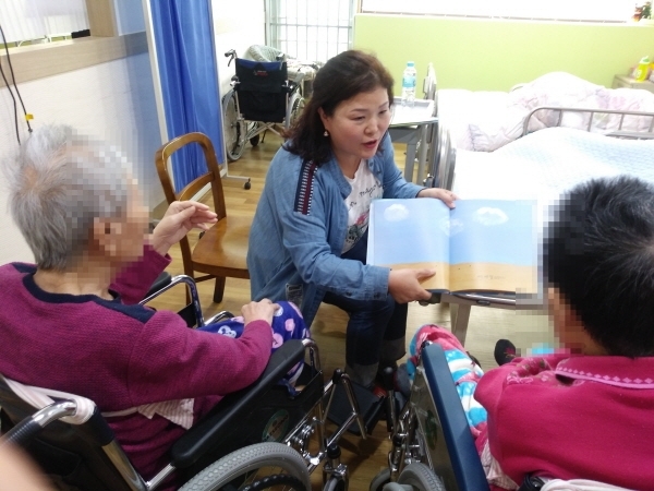 책온봉사단 이미혜 봉사자가 요양시설에서 어르신들에게 책을 읽어주고 있다. 고양시자원봉사센터 제공