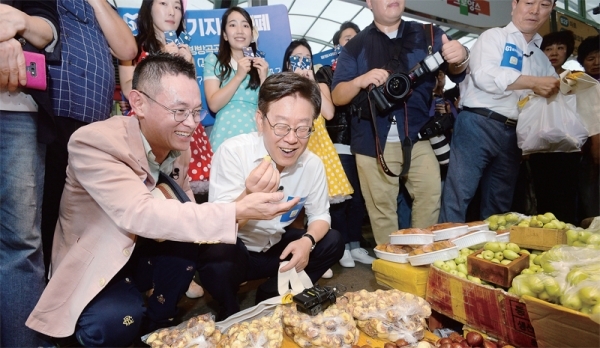 9일 오후 광명전통시장에서 열린 ‘경기지역화폐 방방곡곡 데이트 31’ 행사에 참석한 이재명 경기도지사와 박승원 광명시장 등이 지역화폐카드로 물건을 구입하고 있다. 윤원규기자