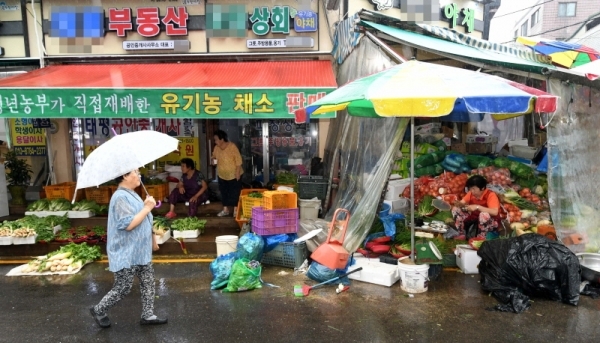 태풍에 이어 가을장마가 계속되면서 도내 재래시장마다 추석 대목임에도 불구하고 손님들의 발길이 크게 줄어 상인들이 울상을 짓고 있다. 비가 내린 10일 수원시내 한 재래시장에서 상인들이 손님을 기다리고 있다. 김시범기자