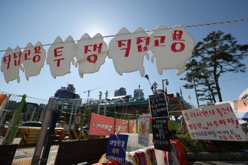 추석인 13일 오전 경기도 성남시 서울톨게이트 농성장에 '직접고용'을 촉구하는 문구가 걸려있다. 한국도로공사에 '전원 직접 고용'을 요구하며 10ｍ 높이 톨게이트 캐노피에서 고공농성을 벌이고 있는 요금수납원들의 투쟁은 추석 명절 연휴에도 이어지고 있다. /연합