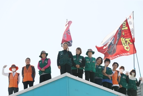 추석인 13일 오전 경기도 성남시 서울톨게이트에서 직접고용을 요구하며 고공농성 중인 톨게이트 요금 수납원들이 용순옥 민주노총 서울본부 수석본부장과 전화통화를 하고 있다.  /연합