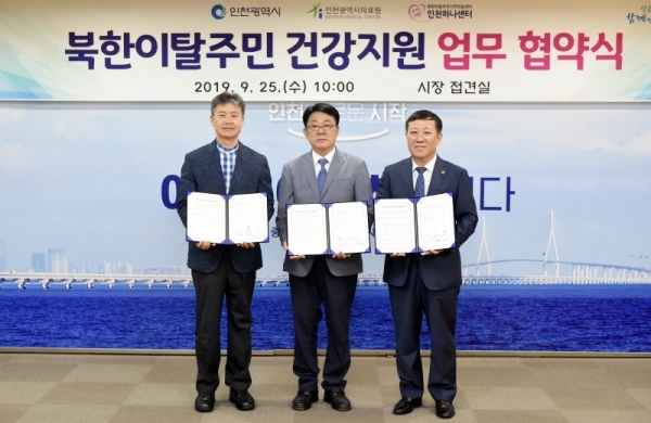 북한이탈주민 건강지원 업무협약식 : 25일 인천 남동구 인천시청 접견실에서 백성현 인천하나센터 이사장(왼쪽부터), 허종식 균형발전정무부시장, 조승연 인천의료원장이 북한이탈주민 건강지원을 위한 업무 협약을 맺고 기념촬영을 하고 있다. 인천시 제공