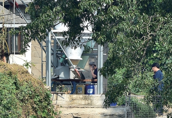 25일 인천 강화군 불은면 한 양돈농장에서 아프리카돼지열병(ASF)이 추가로 확진됐다. 이날 오후 2시께 해당 농장으로 급파된 수의사들이 검역 작업도중 어딘가와 긴급하게 통화하고 있다. 조주현기자