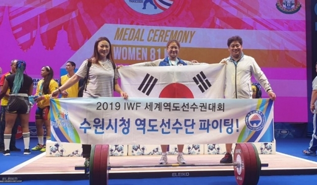 ▲ 25일 밤(현지시간) 태국 파타야에서 열린 2019 세계역도선수권대회 여자 81㎏급 인상에서 금메달을 따낸 이지은(수원시청)이 윤석천 감독, 김미애 코치와 기념촬영을 하고 있다.수원시청 제공