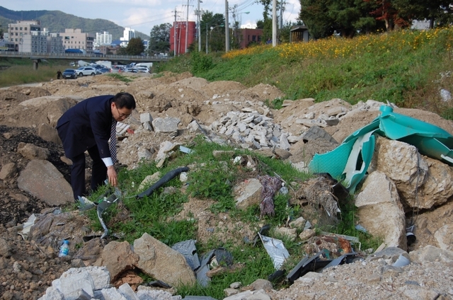 한국전력공사가 지중화 공사 과정에서 나온 각종 폐기물 수백여 t을 몰래 버린 포천천 둔치 일대. 김두현기자