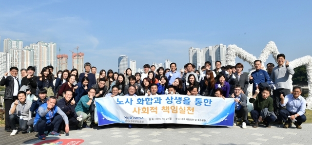 21일 진행된 ‘노사화합을 위한 봉사활동’에 참여한 경과원 임직원들이 광교호수공원에서 단체사진 촬영을 하고 있다.