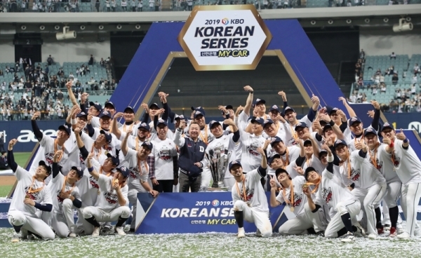 26일 오후 서울 구로구 고척스카이돔에서 열린 2019 프로야구 한국시리즈 4차전 키움 히어로즈와의 경기에서 승리하고 우승을 차지한 두산 베어스 선수들과 코칭스태프들이 우승트로피를 앞에 놇고 포즈를 취하고 있다. 연합뉴스