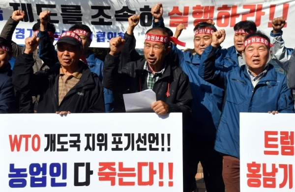 경기도농민단체협의회 회원들이 28일 경기도청 앞에서 열린 ‘정부의 WTO 개발도상국 지위 포기선언 철회 촉구 기자회견’에서 농민의 일방적 희생만 강요하는 정부의 WTO 개발도상국 지위 포기를 규탄하는 구호를 외치고 있다.전형민기자