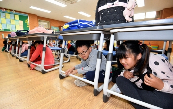 29일 수원시 팔달구 연무초등학교에서 ‘2019 재난대응 안전한국훈련’의 일환으로 열린 지진발생에 따른 건축물 붕괴 및 화재 상황을 가상한 훈련에서 학생들이 책상 밑으로 대피하고 있다.전형민기자