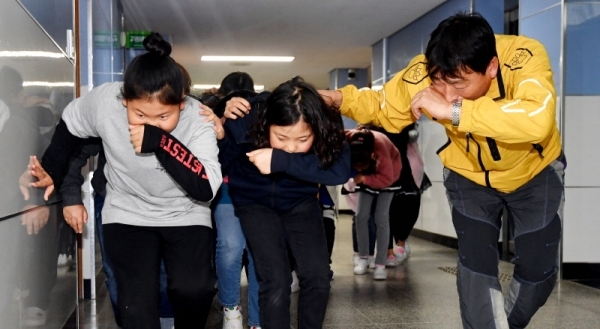29일 수원시 팔달구 연무초등학교에서 ‘2019 재난대응 안전한국훈련’의 일환으로 열린 지진발생에 따른 건축물 붕괴 및 화재 상황을 가상한 훈련에서 학생들이 선생님과 함께 대피하고 있다.전형민기자